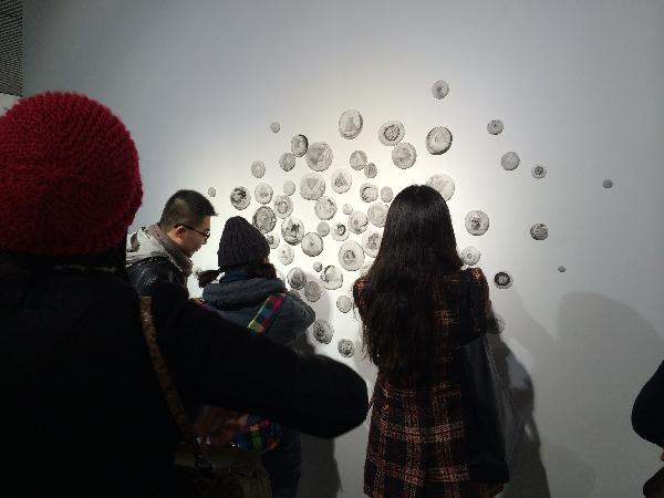 图为：观展人员驻足观看太阳集团城网站2018学子作品